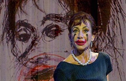 Andrea Eckert als Maria Callas vor einem expressiven Bühnenporträt bei der Aufführung ‚Meisterklasse‘ in Eggenburg