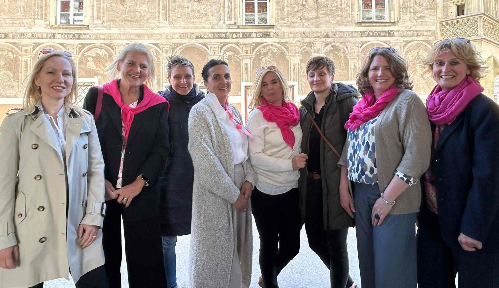 Der Vorstand der Frauentage Eggenburg mit pinken Schals vor einem historischen Gebäude in Wien.